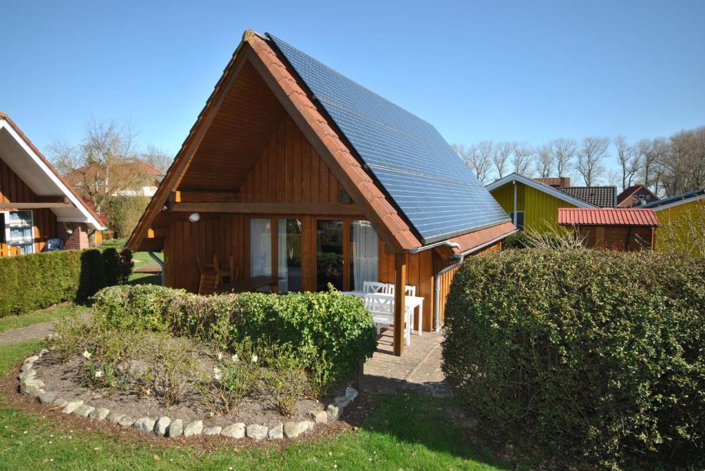 a small wooden house with a metal roof at Ferienhaus Sturmtaucher in Otterndorf