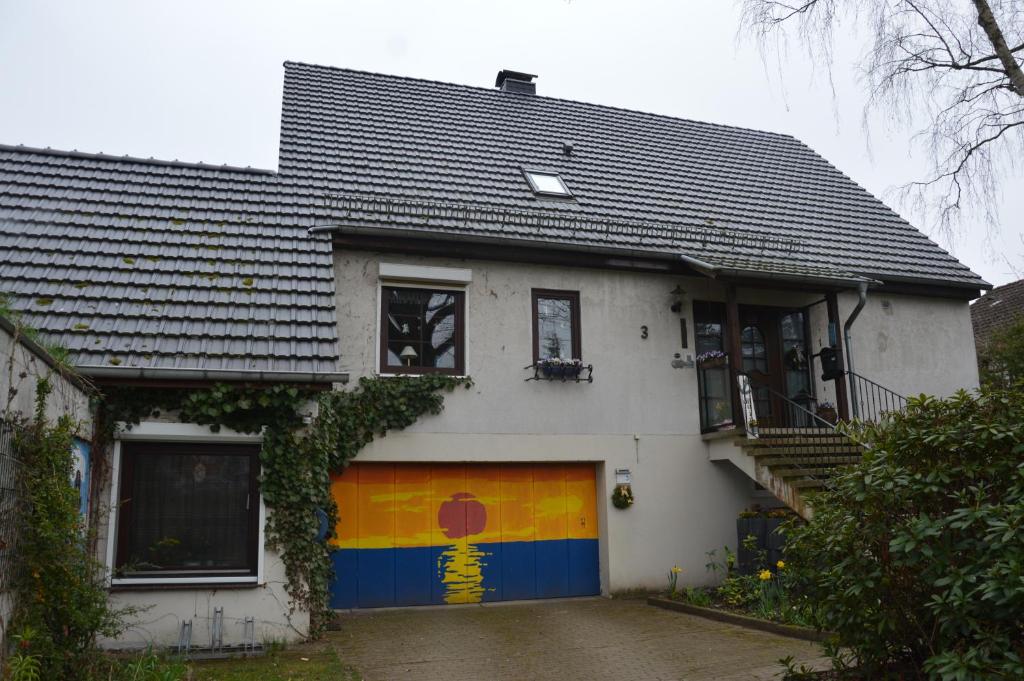 a white house with a garage with a rainbow painted on it at Harten in Büchen