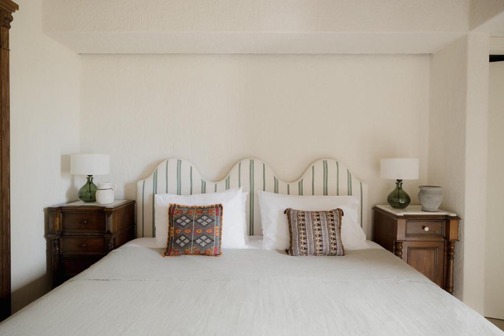 a bedroom with a white bed with two night stands at Koutouloufari Village Holiday Club in Hersonissos