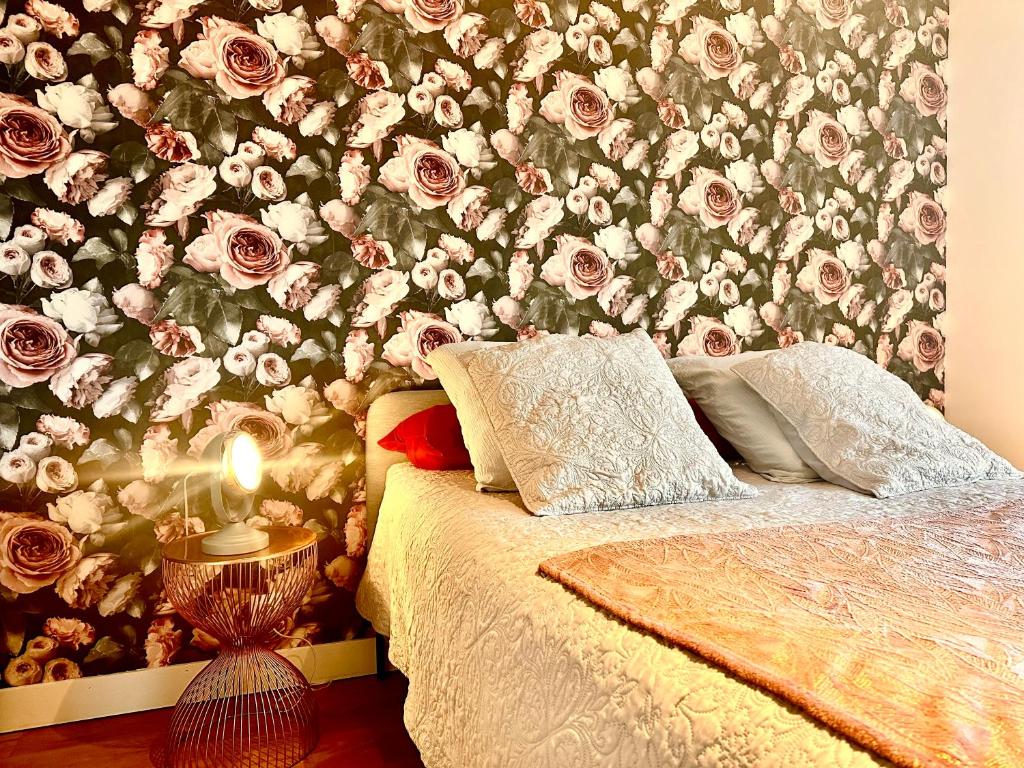 a bedroom with a floral wall with a bed at Le Haut Lieu, Proche Beauval et à deux pas de Loches in Ferrière-sur-Beaulieu