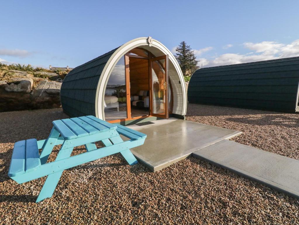 une chaise bleue et une table en face d'une tente en forme de dôme dans l'établissement The Wheelhouse Pod No 6, à Letterkenny