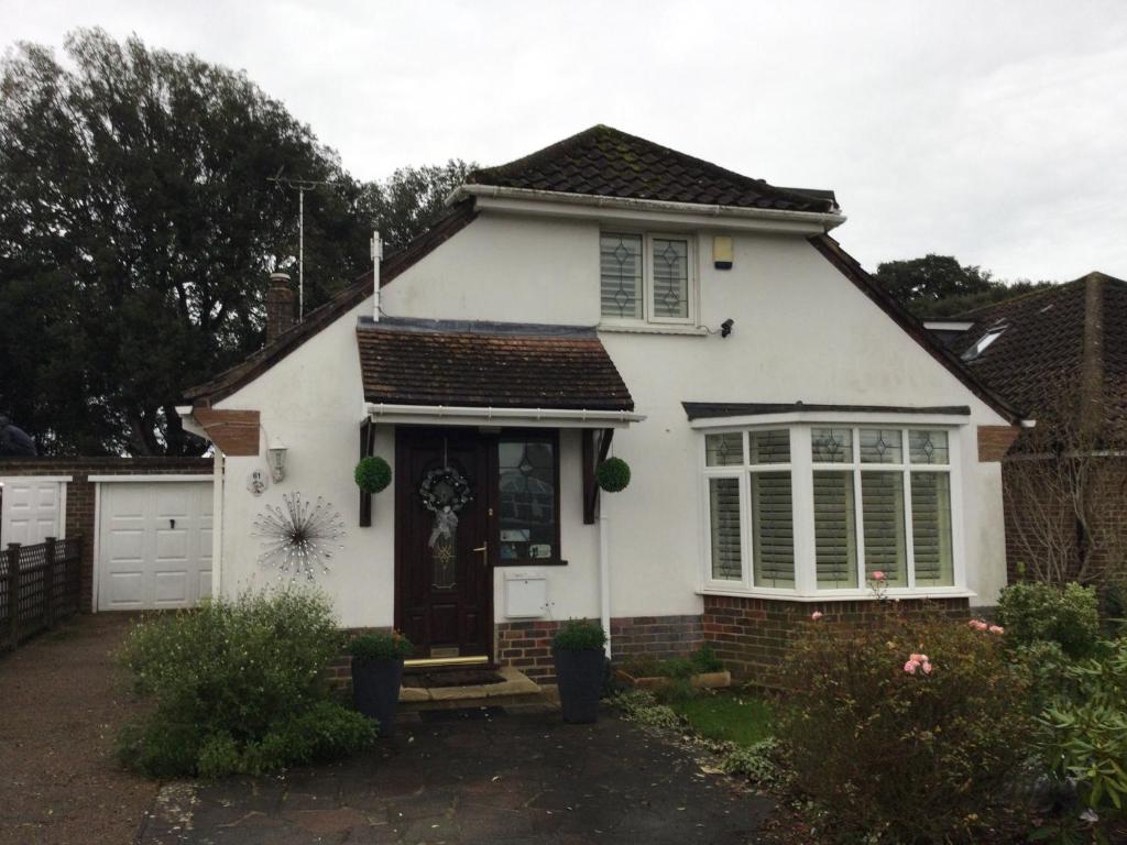 a white house with a door and windows at Comfy and Charming Room in Ferring