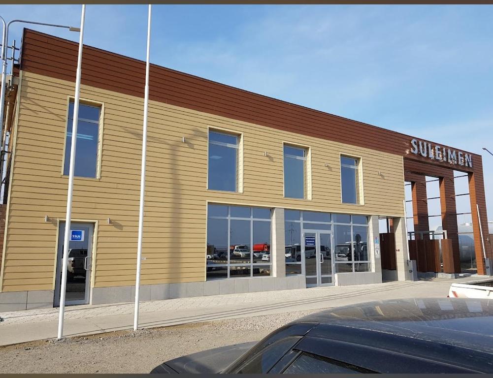 a building with a car dealership in front of it at Sulimen Camp in Tengiz