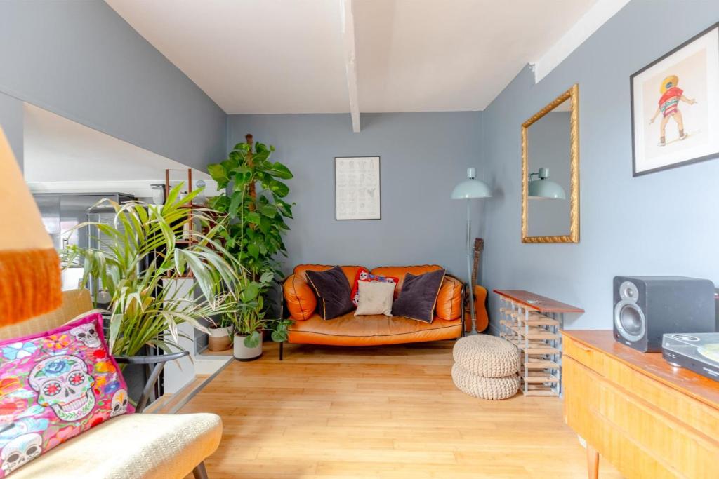 a living room with a couch and some plants at Stylish 2BD Home wPrivate Gym & Garden Newlands! in London