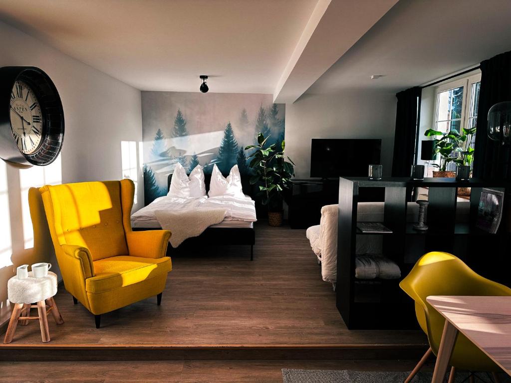 a living room with two beds and a yellow chair at Urban Studio in Buttelstedt