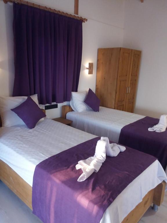 una camera d'albergo con due letti e asciugamani di Esila bungalow sea and nature wiev a Fethiye