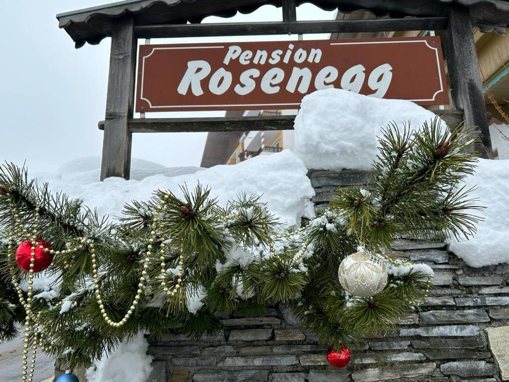 une couronne de christmas sur un bâtiment avec un panneau dans l'établissement Pension Rosenegg, à Finkenberg