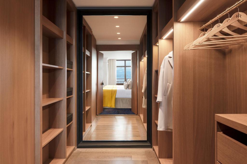 a walk in closet with a bed in the background at Hôtel Royal in Évian-les-Bains