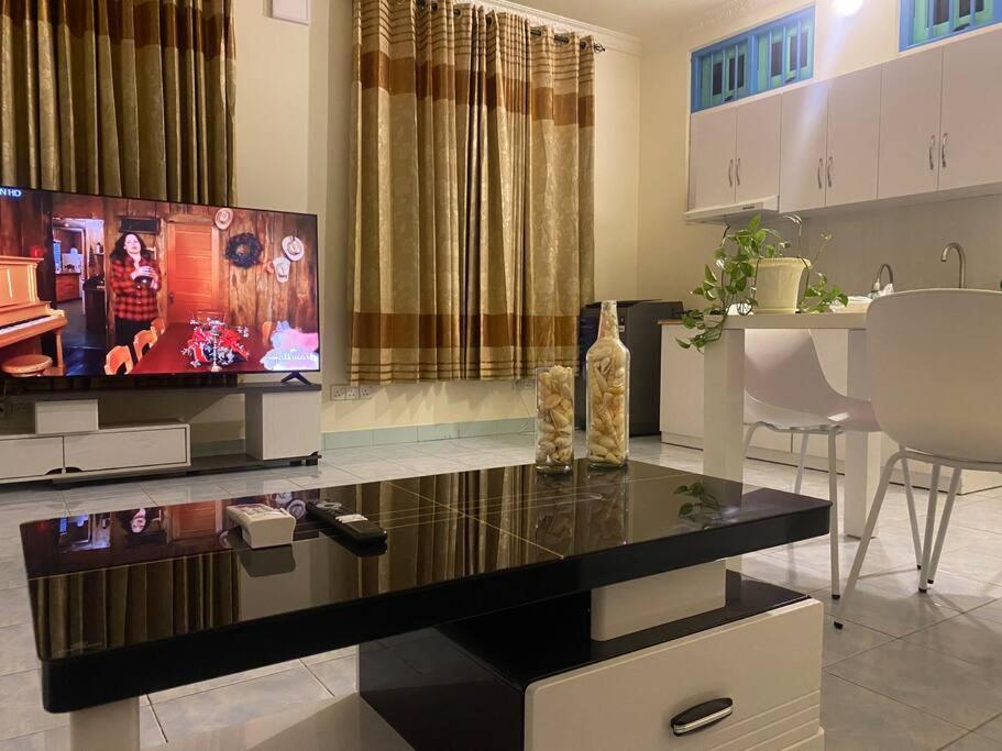 a living room with a tv and a table at Dive Residence - Fuvahmulah, Maldives in Fuvahmulah