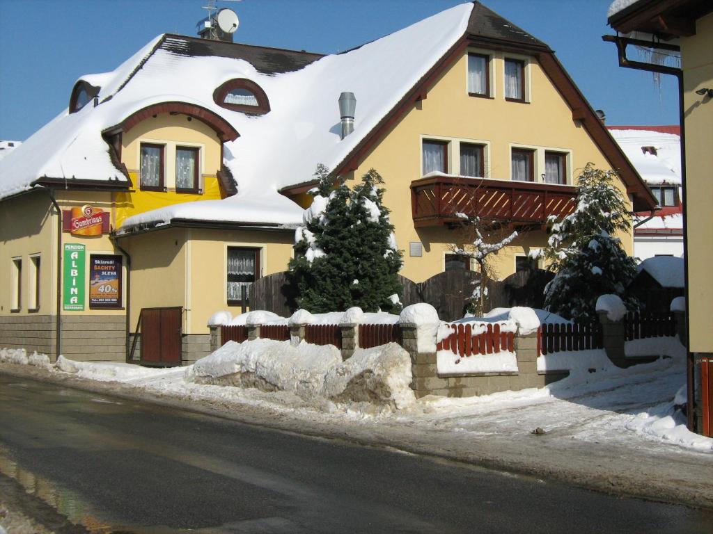 dom z choinką w śniegu w obiekcie Penzion Albína - Restaurace w mieście Vysoké nad Jizerou