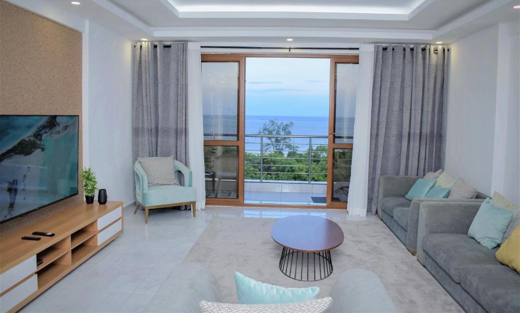 un soggiorno con una grande TV e un divano di THE NEST, Beachfront Serviced Apartment in Nyali - with Panoramic Ocean view a Mombasa