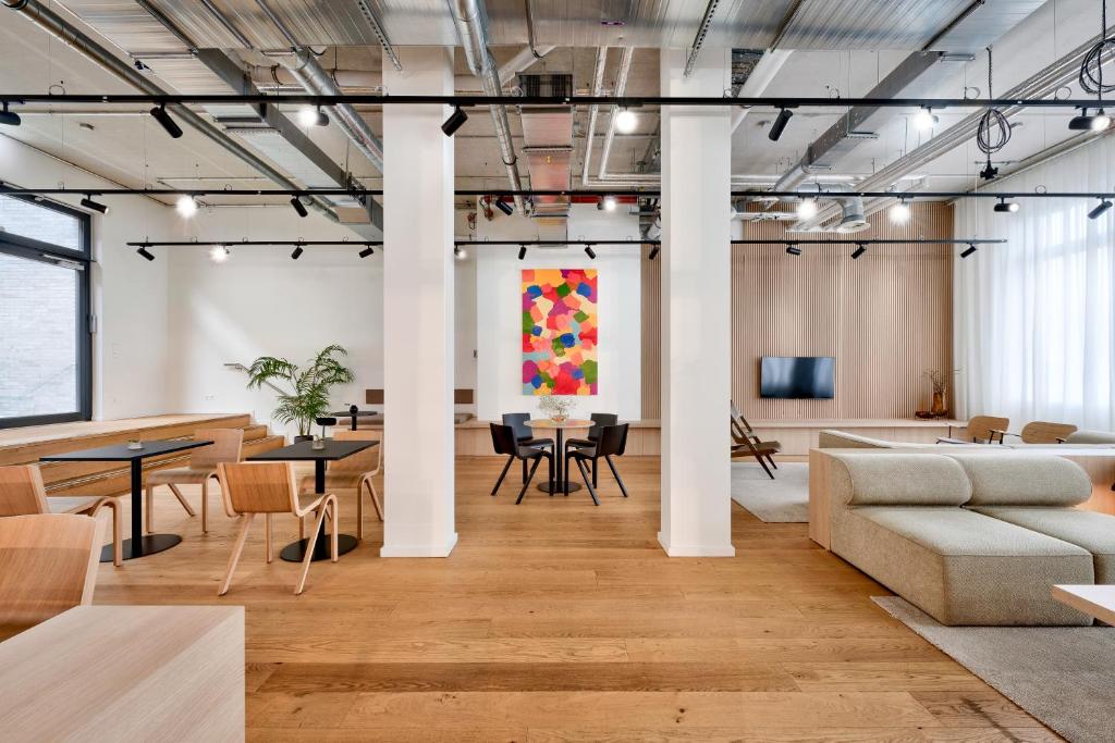 a living room with a couch and tables and a painting at Habyt-The Waterfront in Berlin