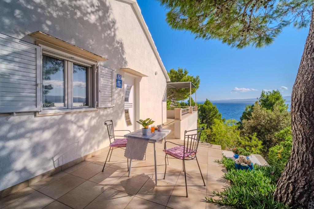 une terrasse avec une table et des chaises et l'océan dans l'établissement Robinson Eda, à Murvica