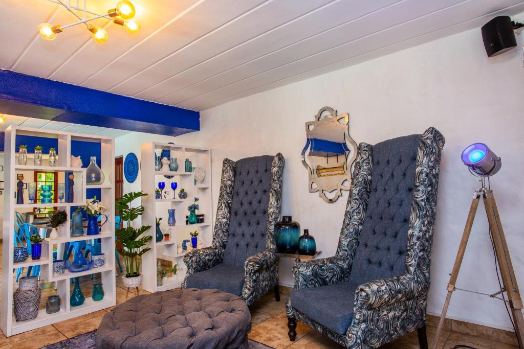 uma sala de estar com duas cadeiras e uma mesa em The Villa Manor & Spa em Bela-Bela