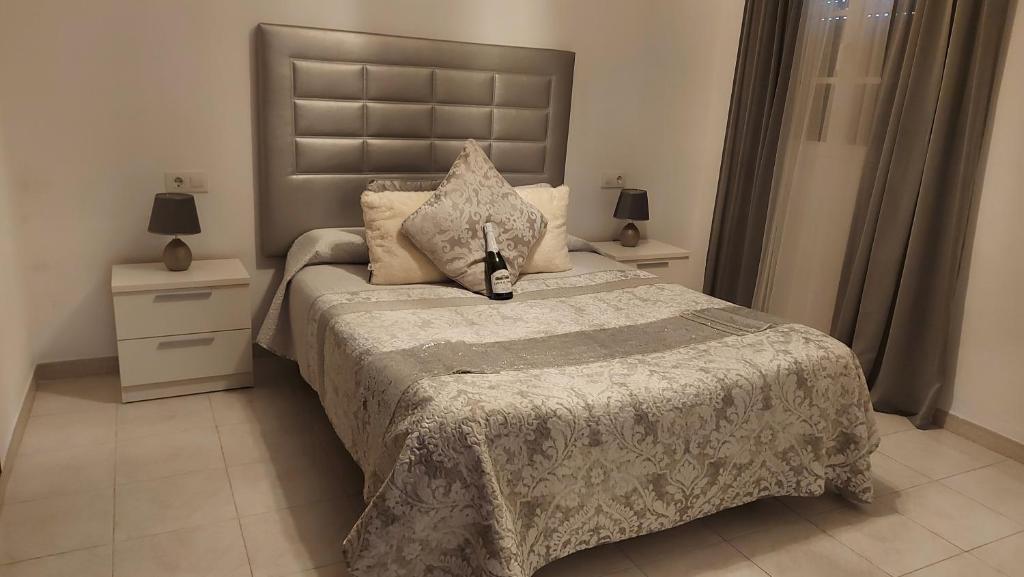 ein Schlafzimmer mit einem großen Bett und zwei Nachttischen in der Unterkunft San Francisco's House in Medina-Sidonia