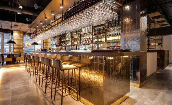 a bar with a row of stools in a restaurant at Stockholm City Chic-1-Bedroom Loft for 3 - 914 in Stockholm