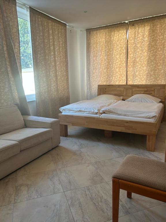 ein Schlafzimmer mit einem Bett, einem Sofa und einem Fenster in der Unterkunft Urban Escape Haven in Hannover