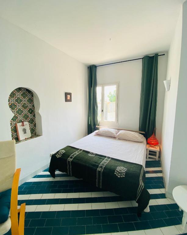 a bedroom with a large bed with a window at Studio bord de mer à louer in Hammam Sousse