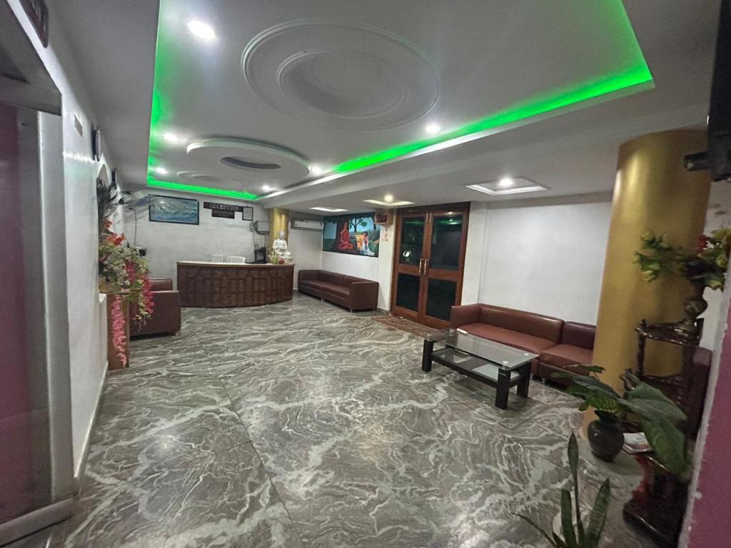 a lobby with a waiting room with a green light at Hotel Maurya Vihar Bodhgaya in Bodh Gaya