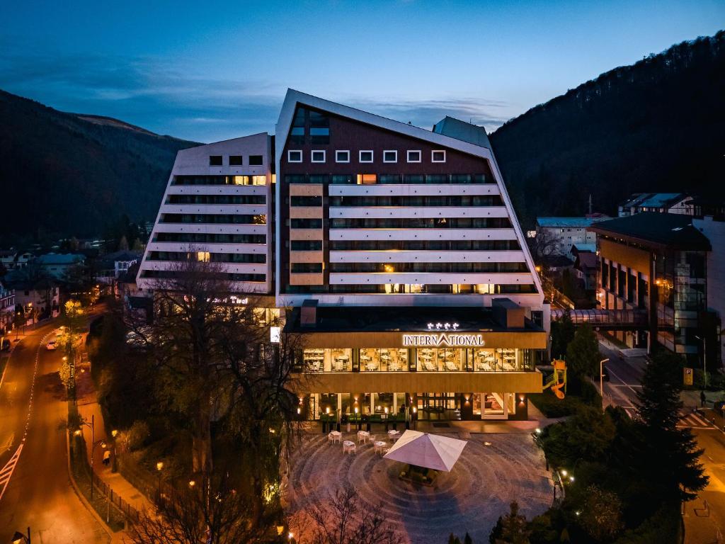 ein großes Gebäude mit Lichtern in einer Stadt in der Nacht in der Unterkunft Hotel International in Sinaia