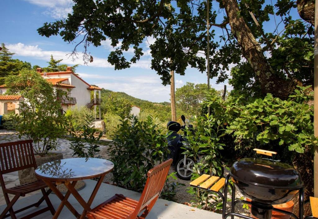 patio ze sprzętem do grillowania, stołem i krzesłami w obiekcie Villa Deborah w mieście Labin