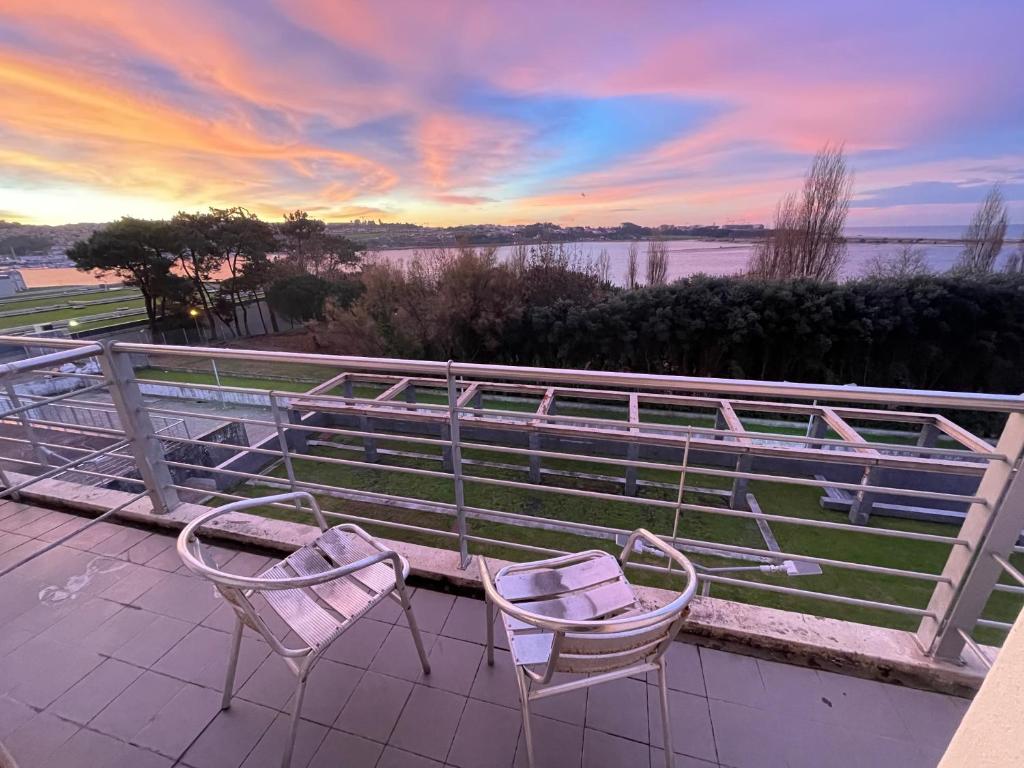 - deux chaises assises sur un balcon au coucher du soleil dans l'établissement HI Porto - Pousada de Juventude, à Porto