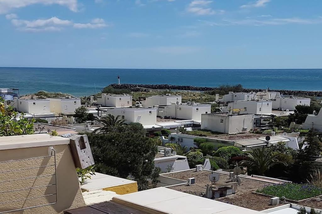 une ville avec des bâtiments blancs et l'océan dans l'établissement Appart 385, Port Nature 3 au village naturiste, au Cap d'Agde