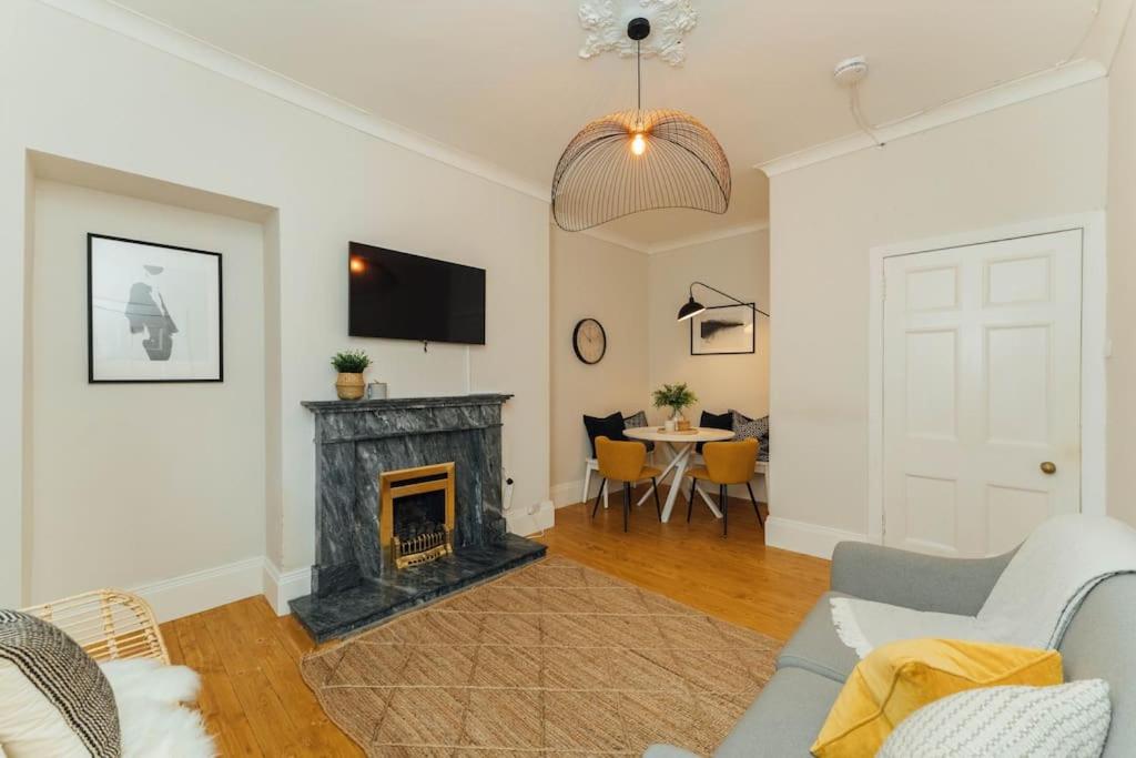 a living room with a fireplace and a tv at Beautifully Renovated 2 Bedroom Apartment in Stirling