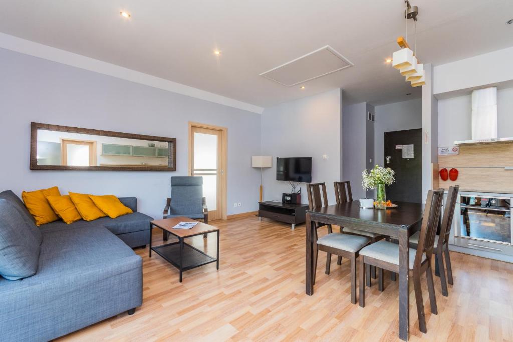 salon z niebieską kanapą i stołem w obiekcie APARTAMENTY MIERZEJA - WILLA TURKUSOWA, Kąty Rybackie w Kątach Rybackich