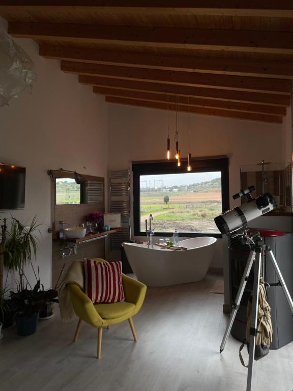 a bathroom with a tub and a camera and a chair at Habitaciones con encanto 