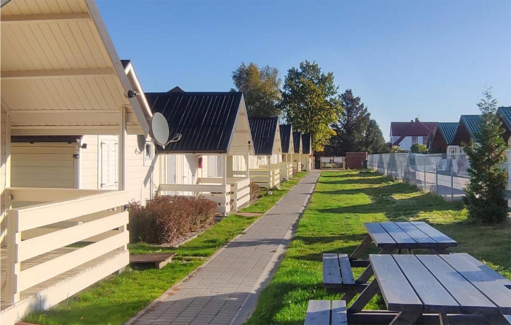 eine Reihe von Häusern mit Picknicktischen im Gras in der Unterkunft Awesome Home In Ustronie Morskie With Kitchen in Ustronie Morskie