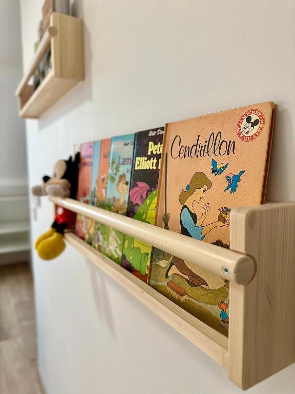 a shelf with childrens books on top of a refrigerator at Au Charme De Bussy - Golf 5 mins, Disneyland 10 mins, Paris 15 miles in Bussy-Saint-Georges