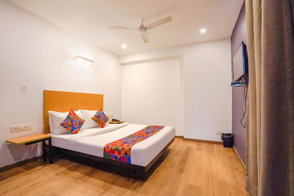 FabHotel Ramayana في Vibhuti Khand: غرفة نوم مع سرير أبيض كبير في غرفة