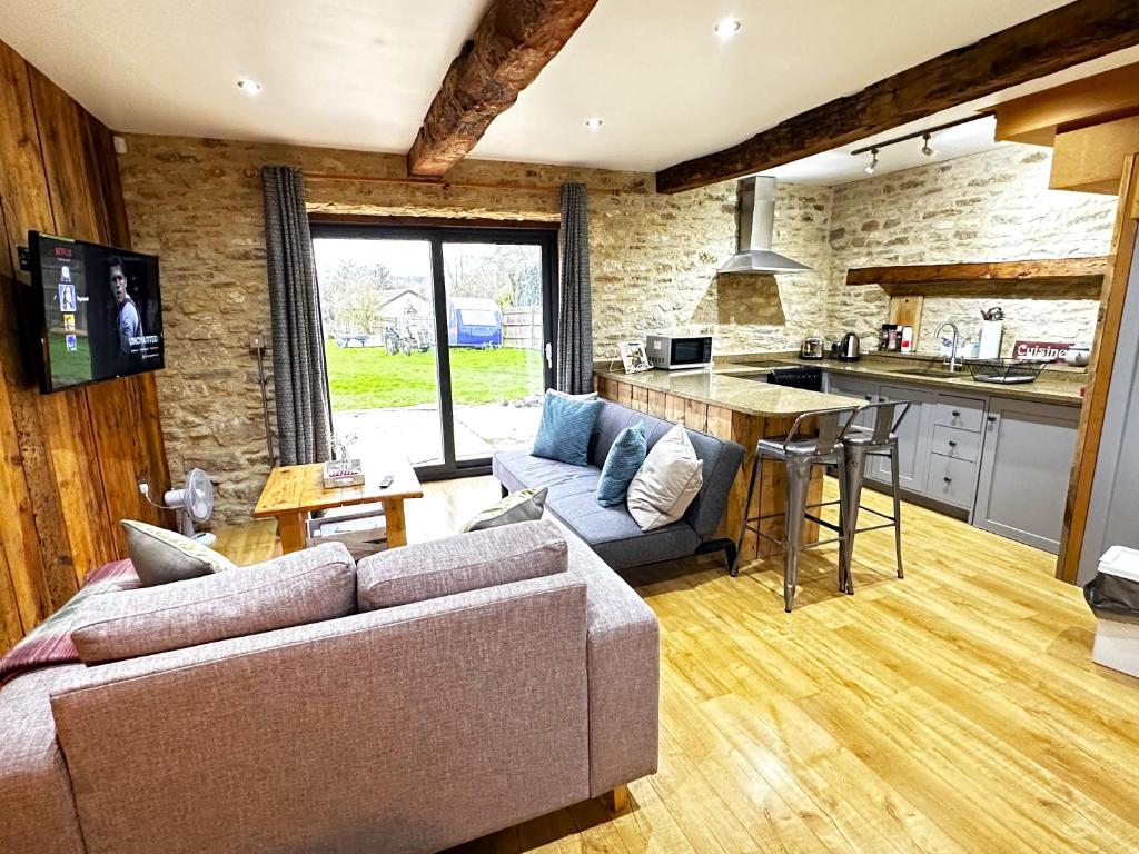a living room with a couch and a kitchen at Dove House Cottages - No 1 in Oxford
