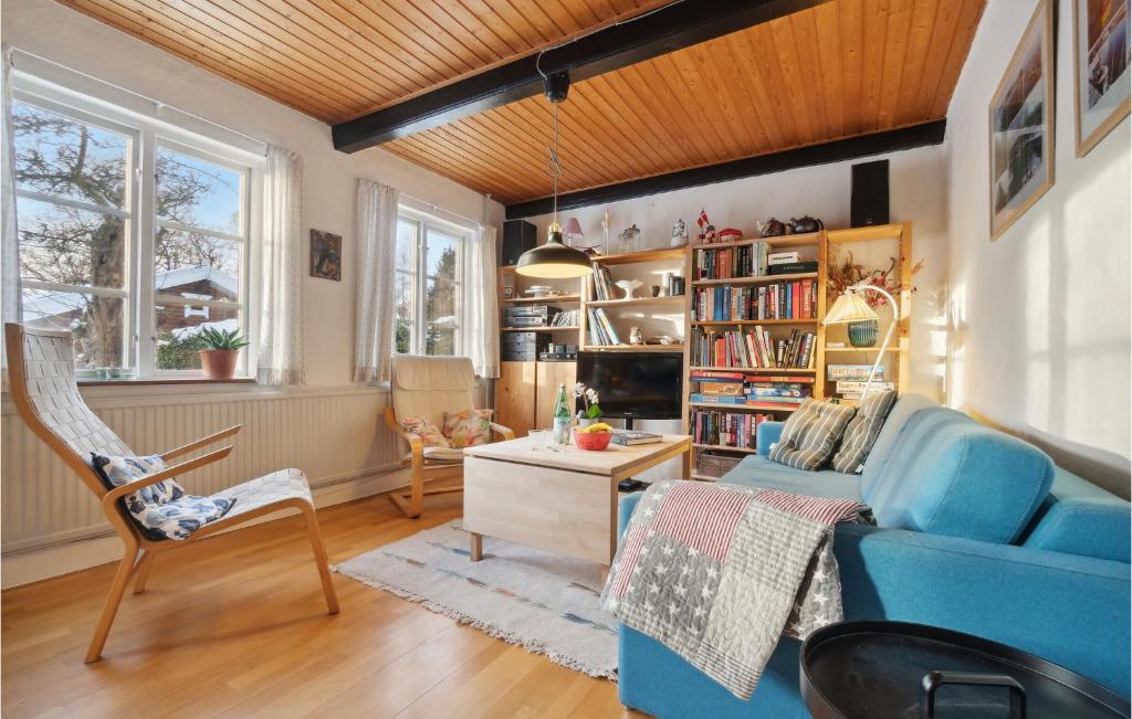 Lovely Home In Hasle With Wifi في Hasle: غرفة معيشة مع أريكة وكراسي زرقاء