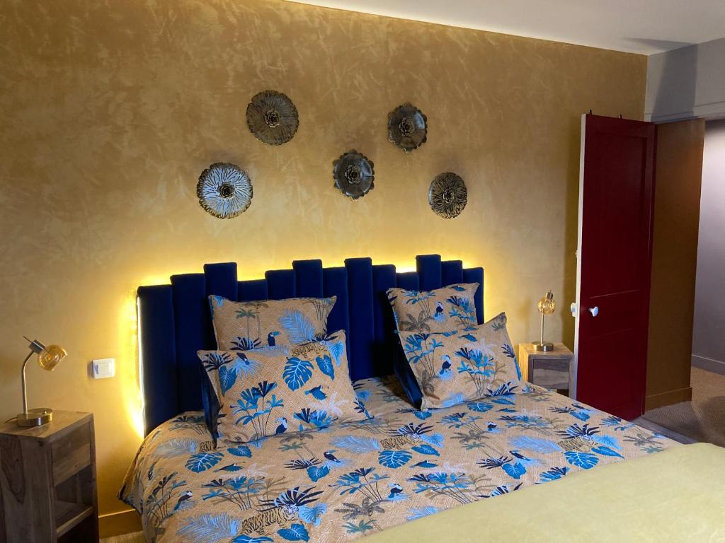 1 cama con cabecero azul en un dormitorio en la detente de neuilly en Neuilly