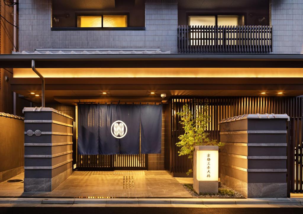 einen Eingang zu einem Gebäude mit einem schwarzen Tor in der Unterkunft Kyoto Sanjo Ohashi in Kyoto