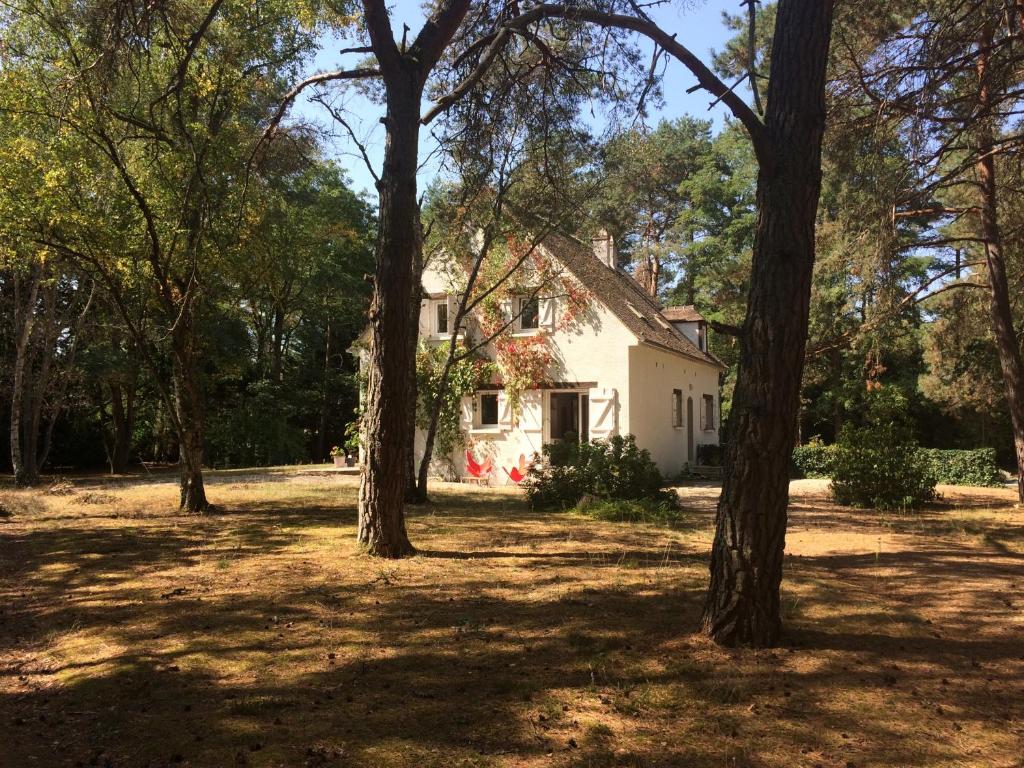 une maison blanche avec des arbres devant dans l'établissement Maison au coeur du Massif des Trois Pignons, à Noisy-sur-École
