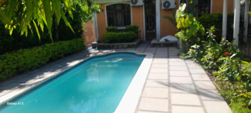 a swimming pool in front of a house at The Villa in Grand Baie