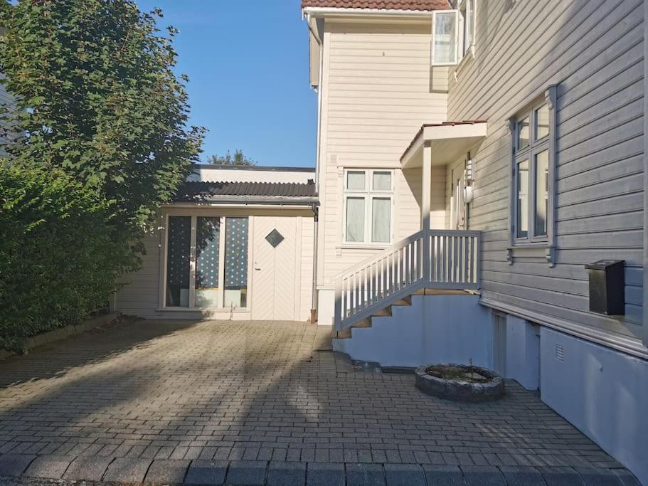 a house with a porch and a staircase in front of it at Nice 1-bedroom apartment in Heart of the City in Stavanger