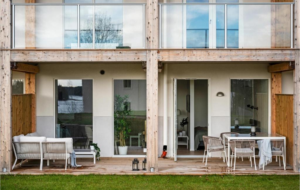 uma casa com portas de vidro e uma mesa num deque em Gorgeous Apartment In Stjrnhov With House Sea View em Stjärnhov