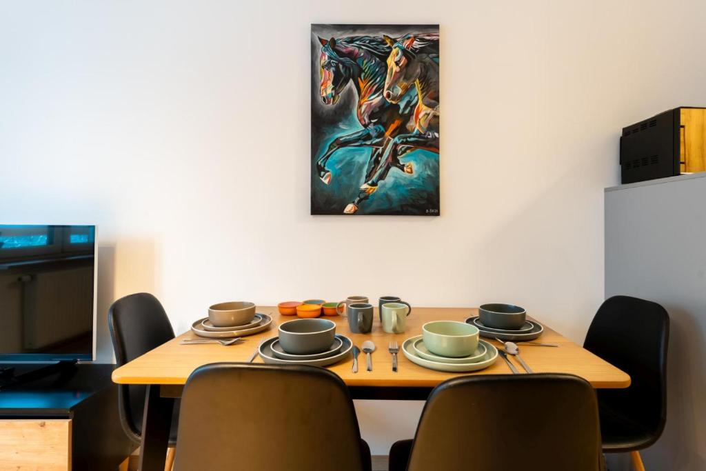 施柯拉爾斯卡波倫巴的住宿－Apartament Reglowy Raj - z prywatnym parkingiem by SpaceApart，餐桌、椅子和墙上的绘画