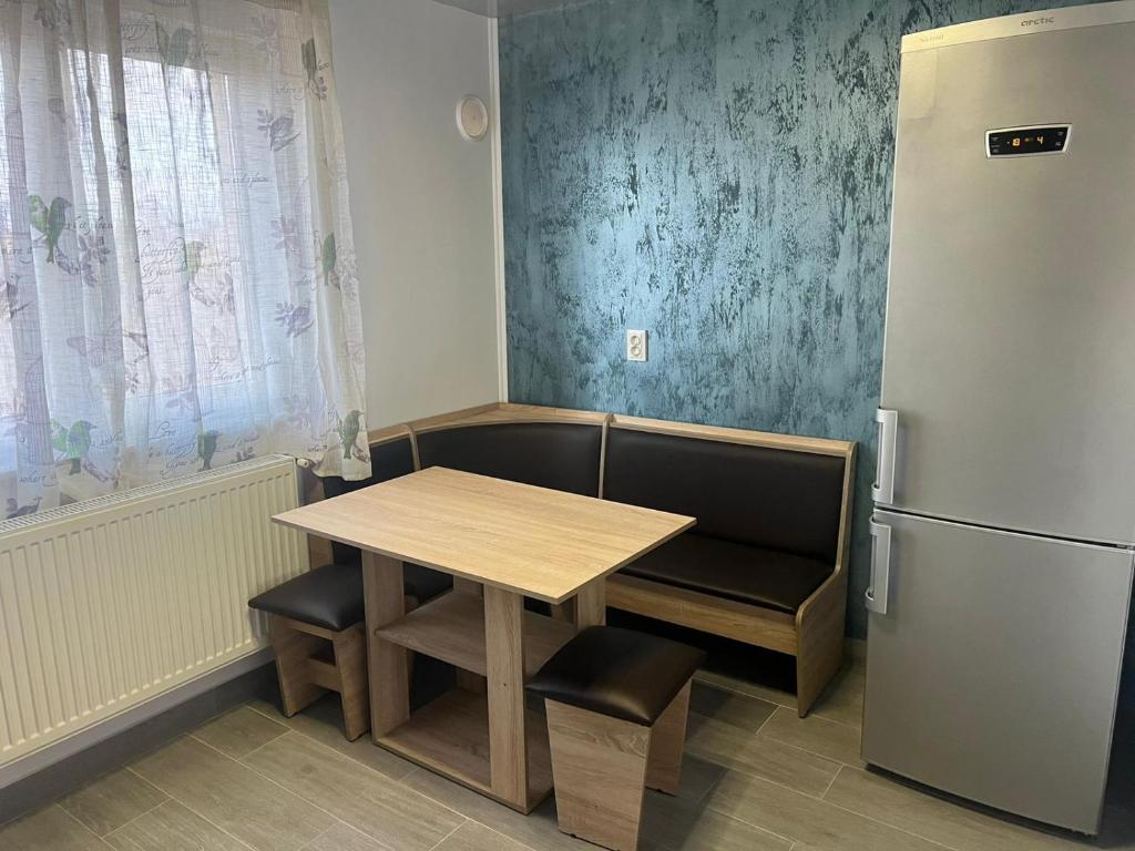 a small kitchen with a table and a refrigerator at Sipotul Apelor in Domneşti