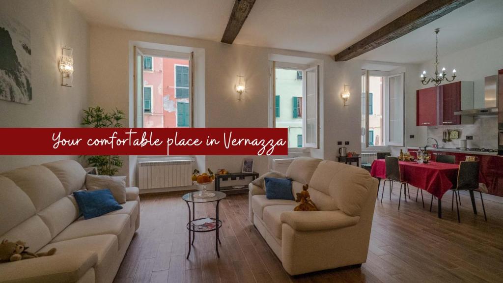 a living room with two couches and a kitchen at Tedea Apartment in Vernazza