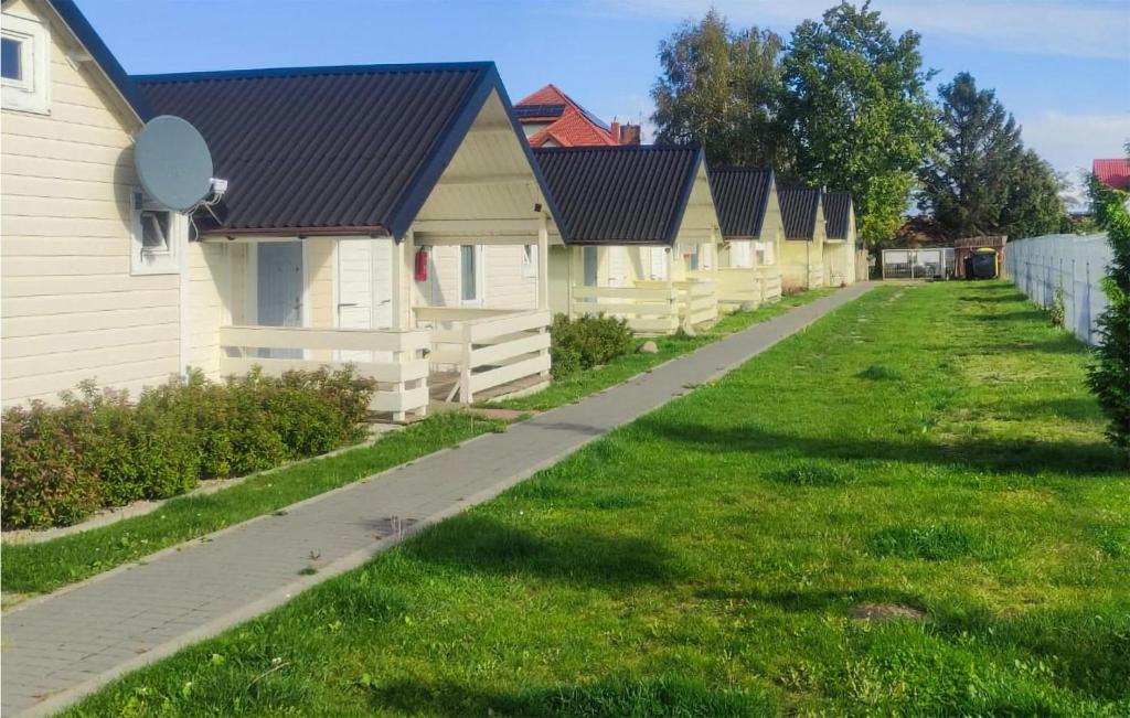 a row of houses on a grassy yard at Pet Friendly Home In Ustronie Morskie With Kitchen in Ustronie Morskie