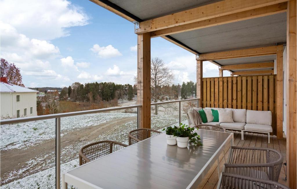 een veranda met een tafel en stoelen en uitzicht op de sneeuw bij 3 Bedroom Amazing Apartment In Stjrnhov in Stjärnhov