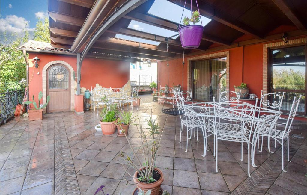 un patio con tavoli, sedie e piante bianchi di Amazing Apartment In Palestrina With Kitchen a Palestrina