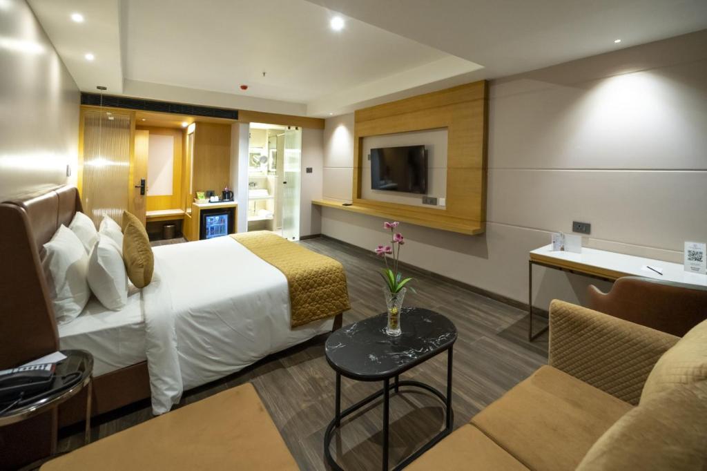a hotel room with a bed and a couch at Regenta Inn Bhavani Nellore By Royal Orchid Hotels in Nellore
