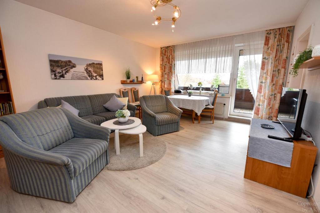 uma sala de estar com um sofá, uma televisão e uma mesa em Haus "Luv und Lee" Appartement LUV31 em Cuxhaven