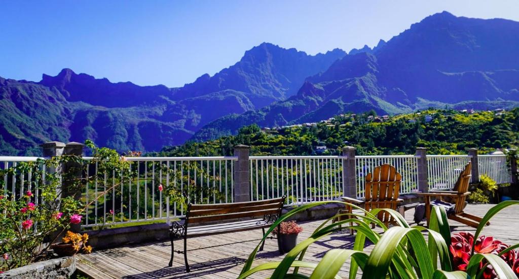 a balcony with two chairs and a view of mountains at le paradis d'Elise in Cilaos